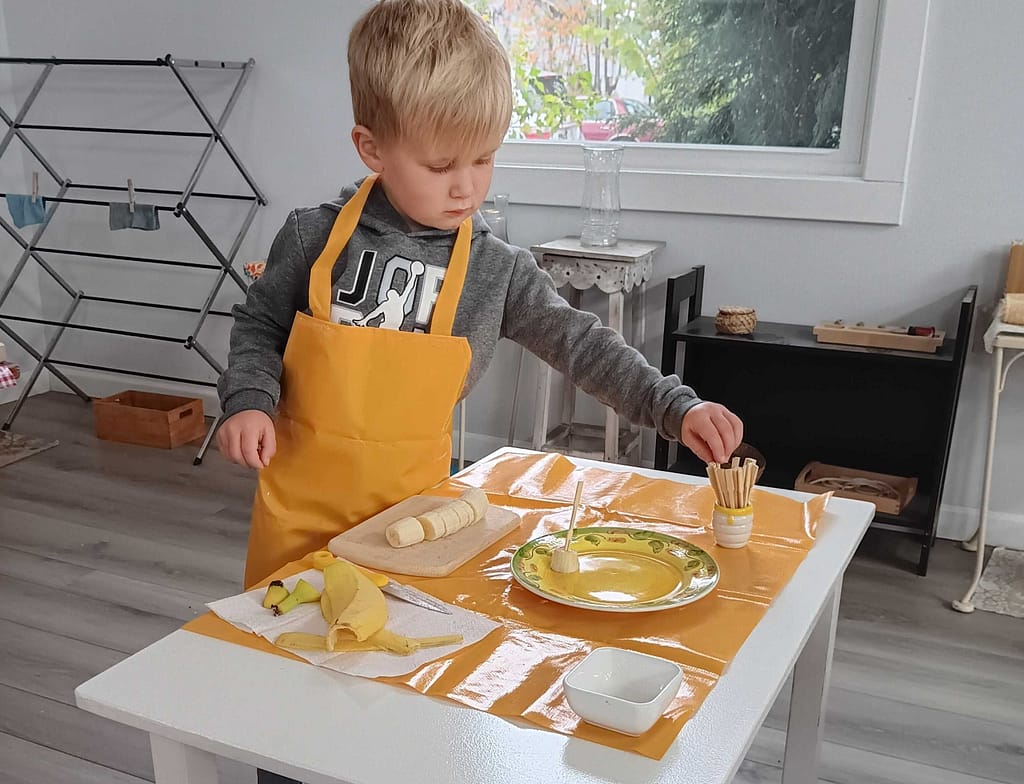 Micah Slicing Bananas | Hilltop Montessori School